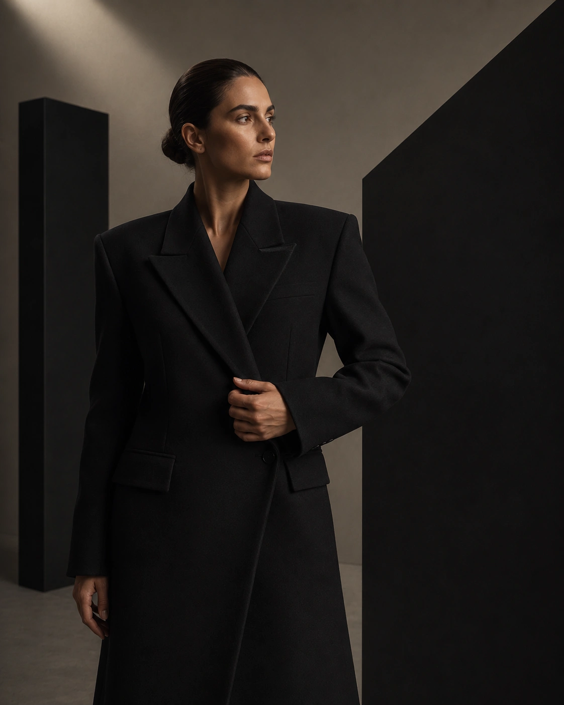 Portrait in black tailoring with a hand at the lapel