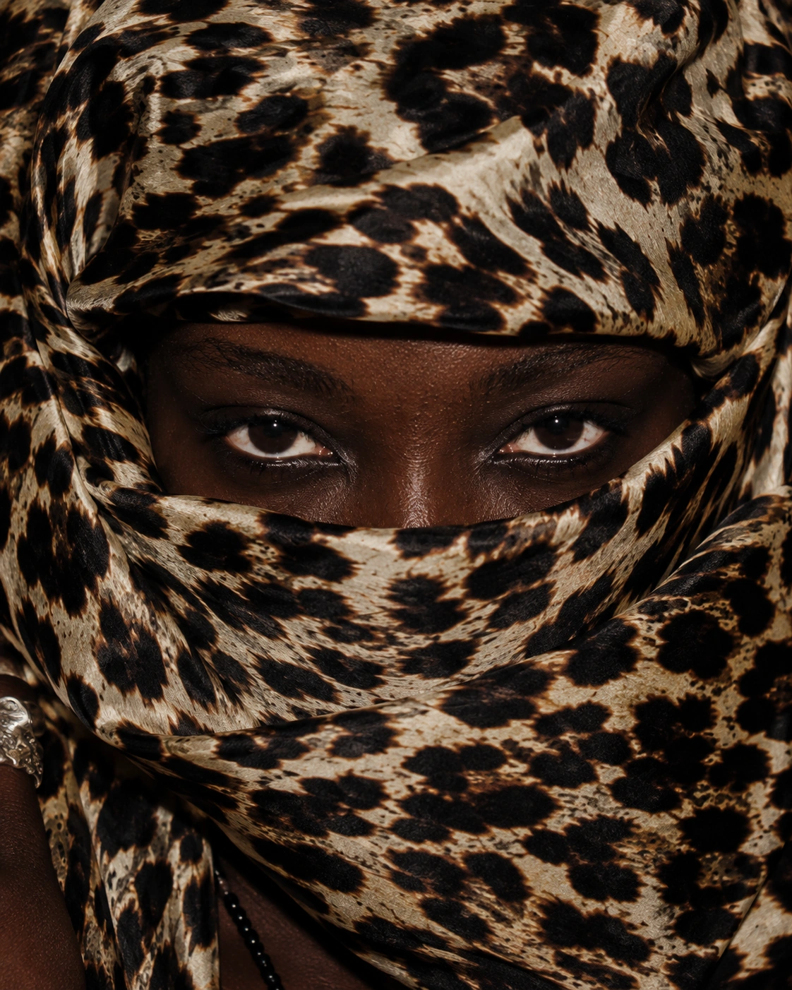 Eyes framed closely by leopard-pattern cloth